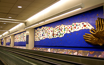 An 80 foot long cloud of 1200 child-created ceramic objects connects two sets of open hands at Philadelphia International Airport.